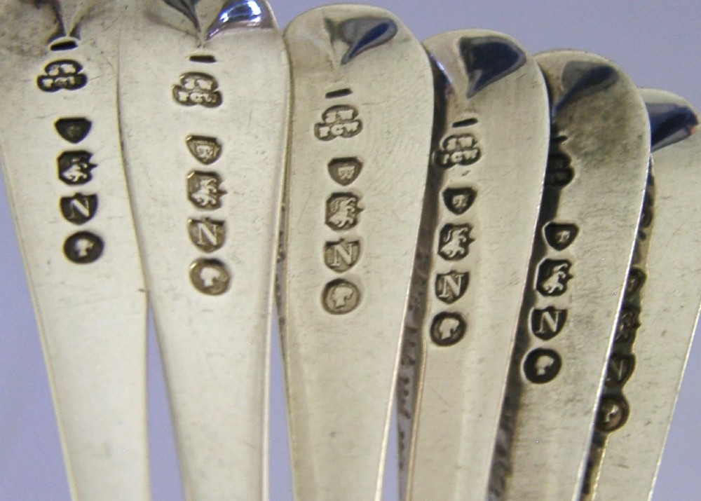 A set of six engraved Victorian sterling silver spoons arranged inside a black fitted presentation case lined with deep purple velvet. View XII