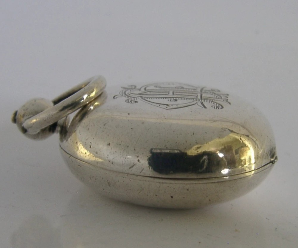 An open circular Victorian sterling silver sovereign case displaying an internal spring-loaded coin platform and hallmarks on the inner lid. View V