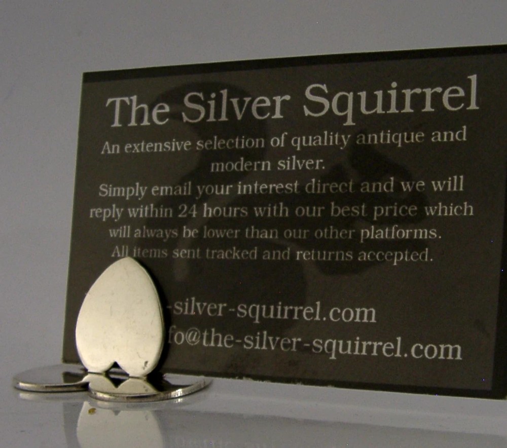 An Edwardian sterling silver menu holder featuring an upright heart clip on a double-heart flat base. View IV
