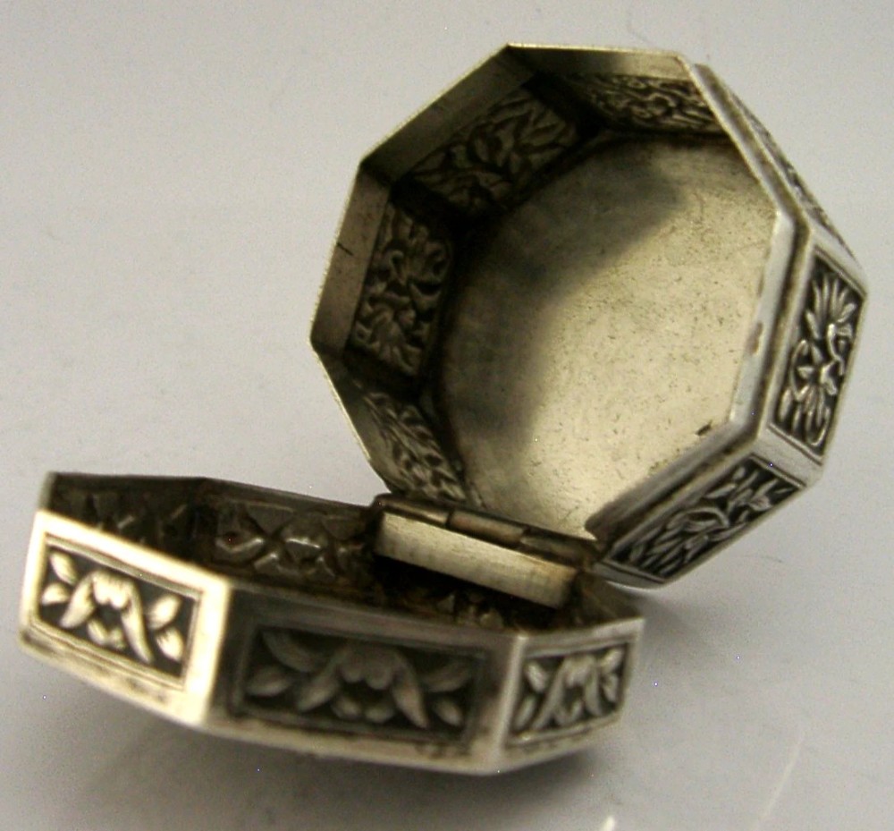 An octagonal Chinese export silver box featuring relief panels with floral and botanical motifs. View IV