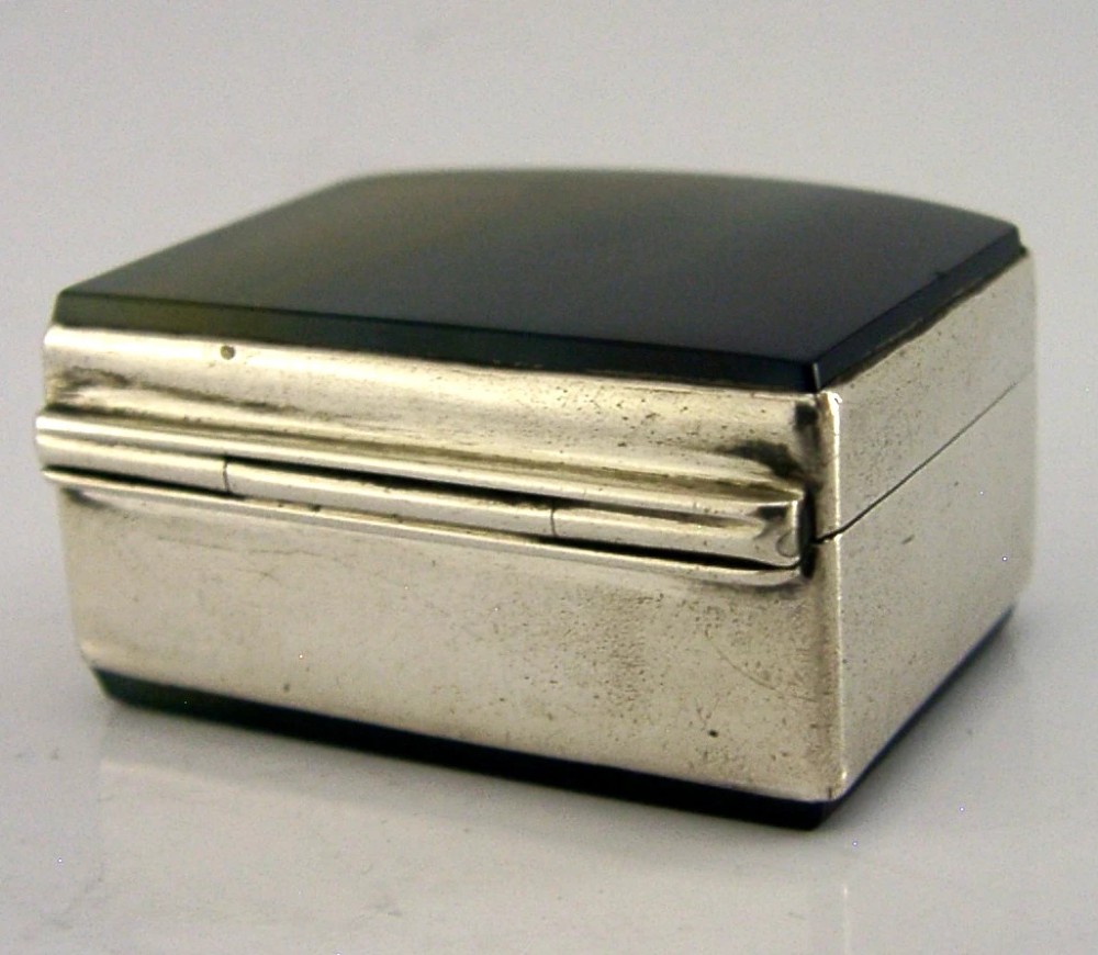A small hinged sterling silver box featuring an arched lid mounted with a polished blue and yellow banded agate stone. View VI