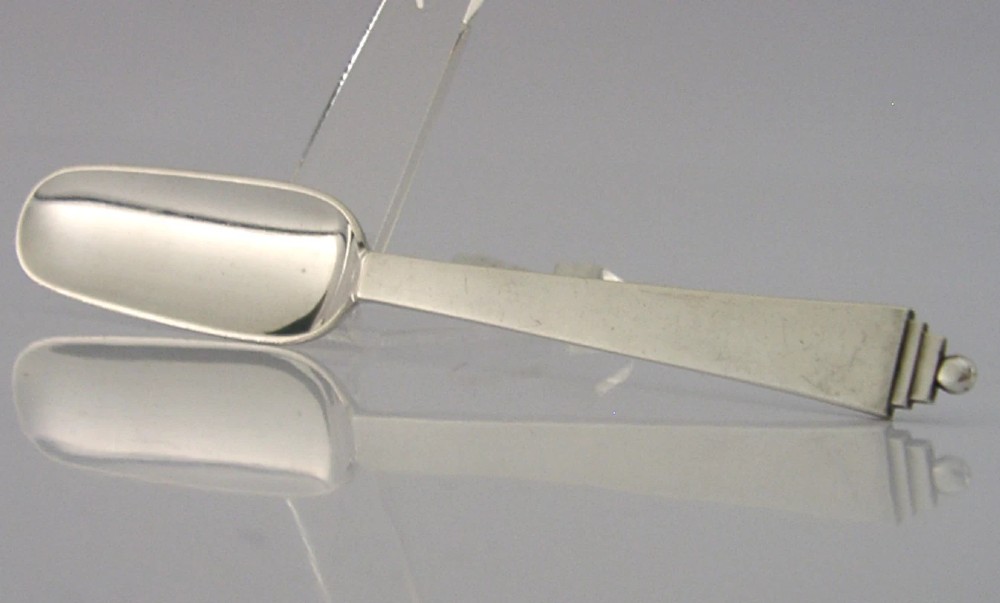 A sterling silver Stilton cheese scoop featuring a tapered handle ending in a stepped pyramid finial. View III