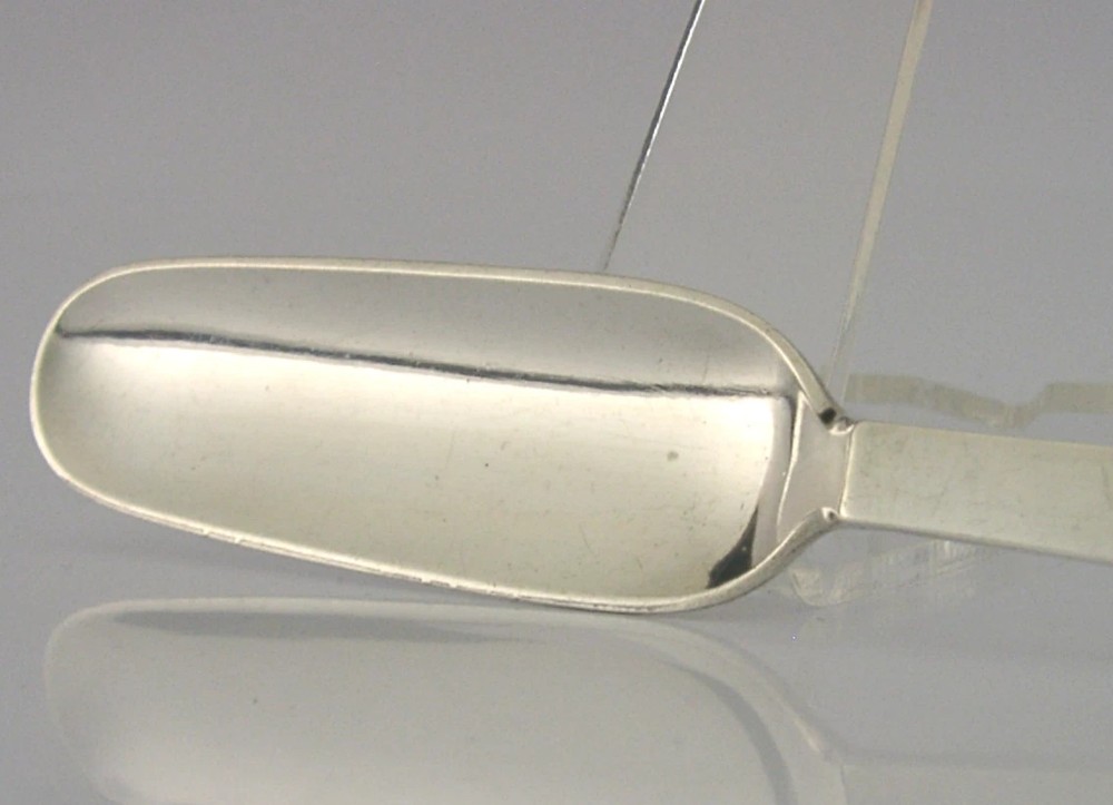 A sterling silver Stilton cheese scoop featuring a tapered handle ending in a stepped pyramid finial. View V