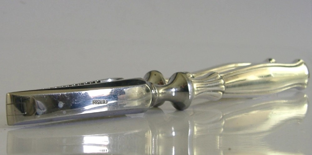 A pair of mid-century German nutcrackers featuring smooth silver handles and serrated metal jaws connected by a central hinge. View III