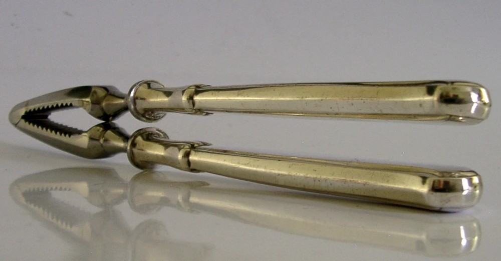A pair of mid-century German nutcrackers featuring smooth silver handles and serrated metal jaws connected by a central hinge. View IV