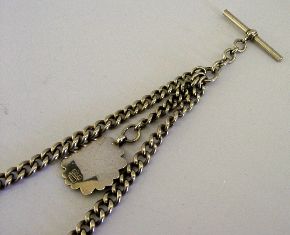 A solid sterling silver double Albert watch chain featuring curb links, a T-bar, two swivel clasps, and a decorative shield fob. View VII