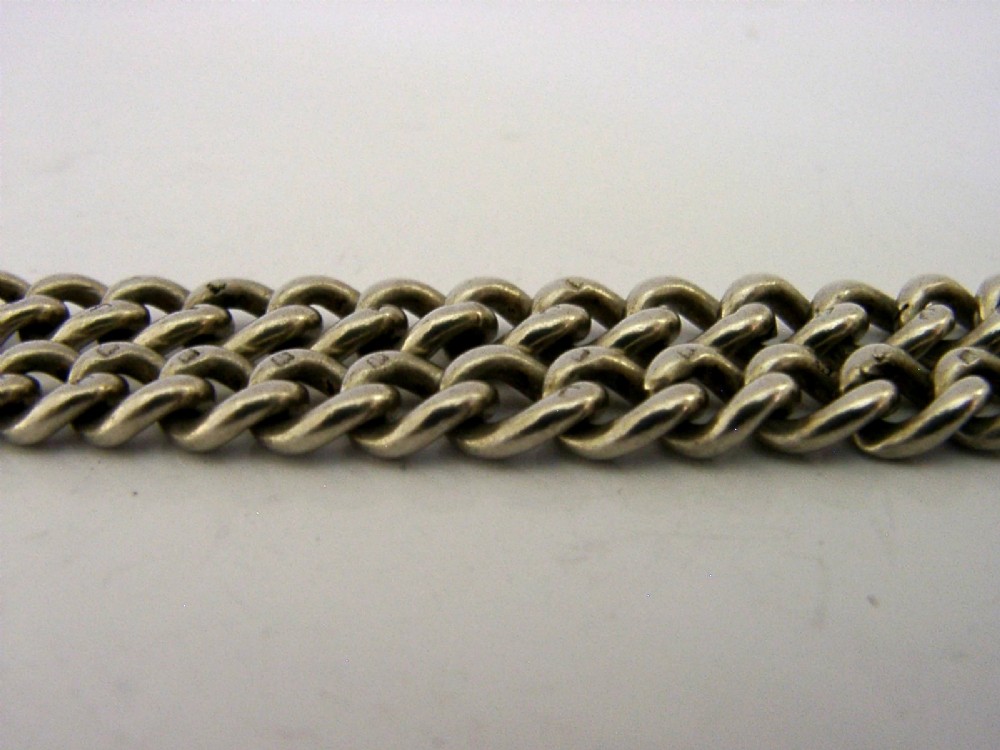 A solid sterling silver double Albert watch chain featuring curb links, a T-bar, two swivel clasps, and a decorative shield fob. View VIII