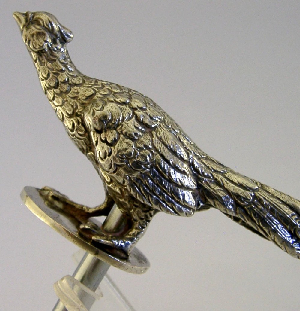 A sterling silver corkscrew featuring a sculpted handle in the shape of a pheasant in flight attached to a steel worm. View II