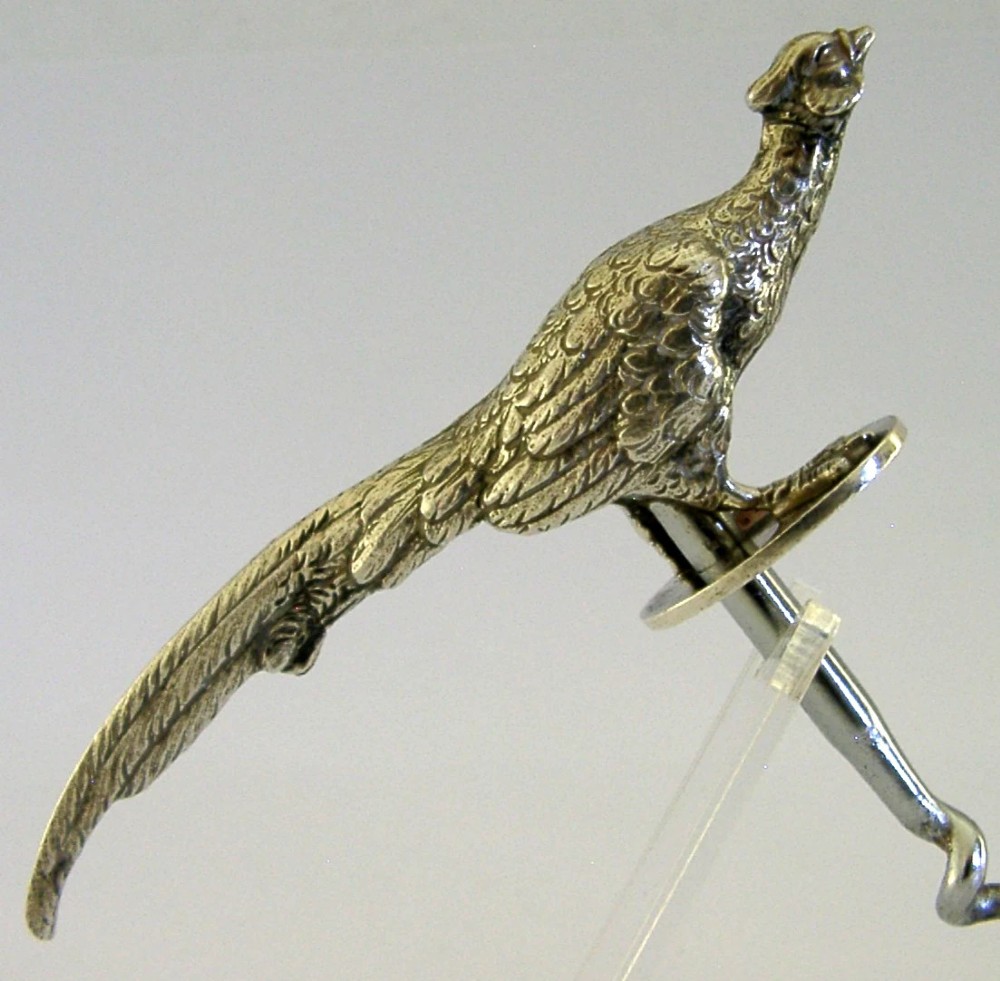 A sterling silver corkscrew featuring a sculpted handle in the shape of a pheasant in flight attached to a steel worm. View V