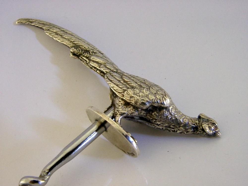 A sterling silver corkscrew featuring a sculpted handle in the shape of a pheasant in flight attached to a steel worm. View X