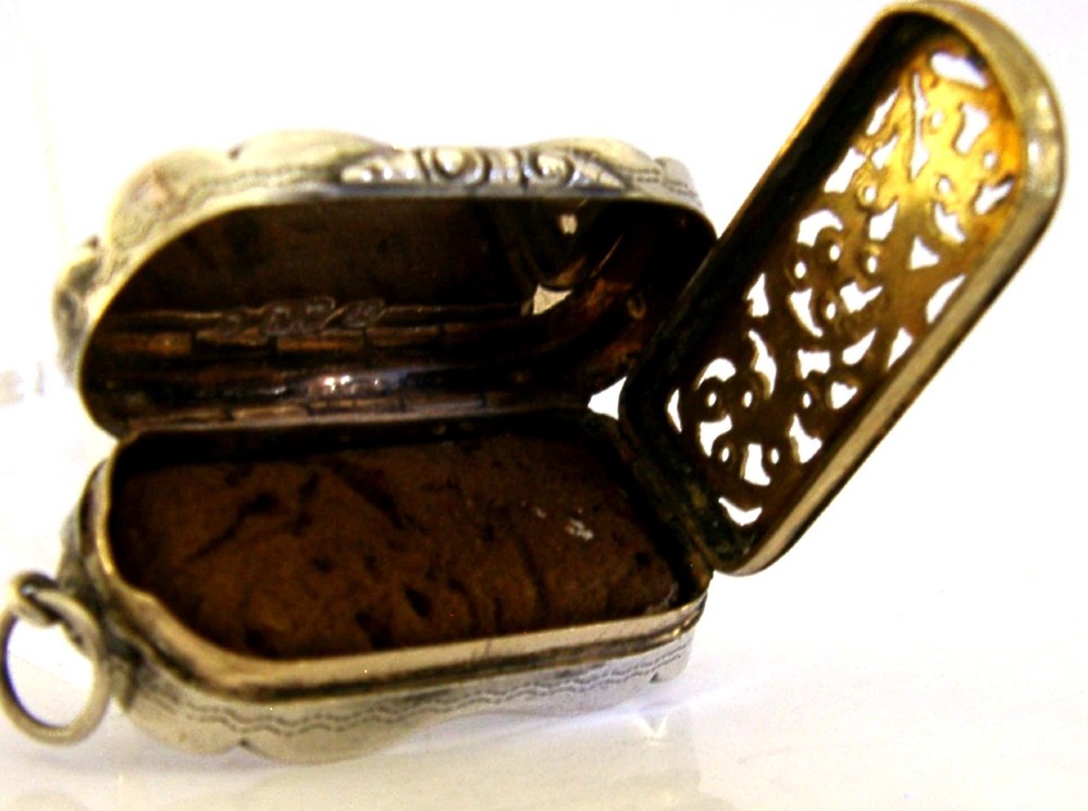 An antique Victorian sterling silver vinaigrette box featuring a shaped lobed outline, engine-turned geometric engraving, and a central engraved monogram cartouche. View II