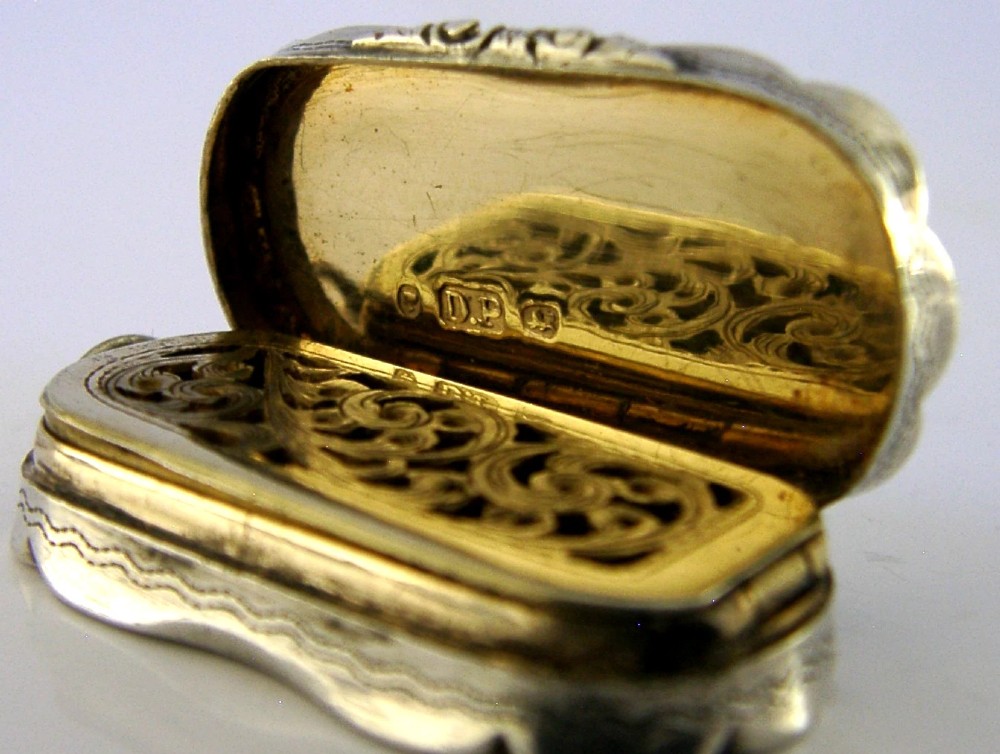 An antique Victorian sterling silver vinaigrette box featuring a shaped lobed outline, engine-turned geometric engraving, and a central engraved monogram cartouche. View XII