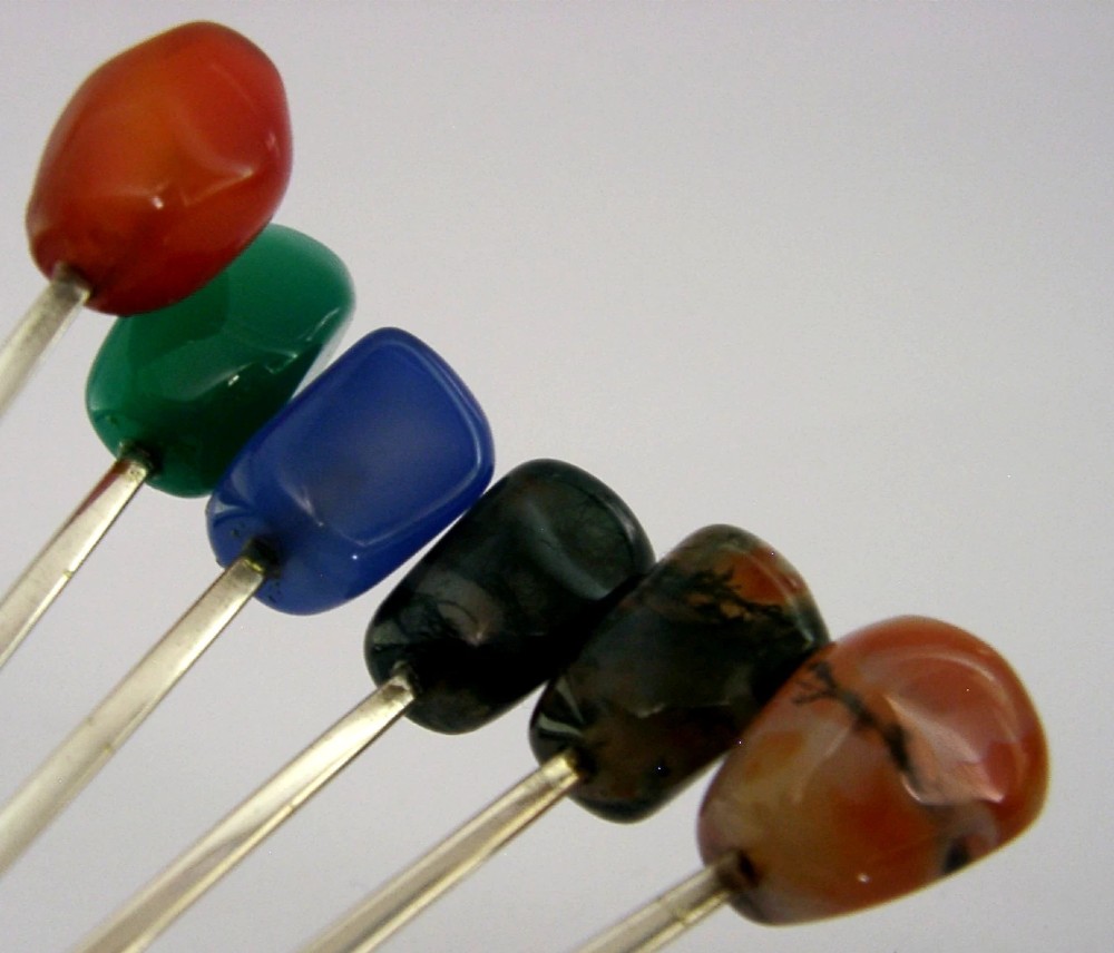 A cased set of six sterling silver coffee spoons with assorted colourful polished agate finials arranged in a dark lined presentation box. View III