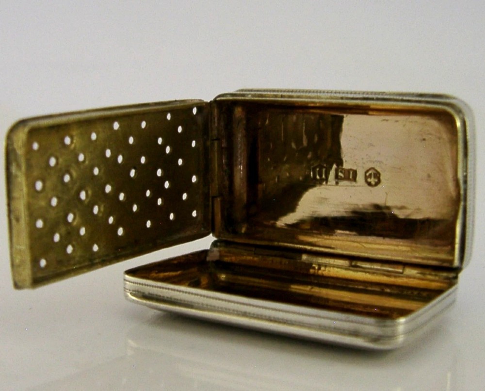 An open rectangular Georgian sterling silver vinaigrette box displaying an engraved exterior and a pierced gold-gilded inner grille featuring floral leaf patterns. View IV