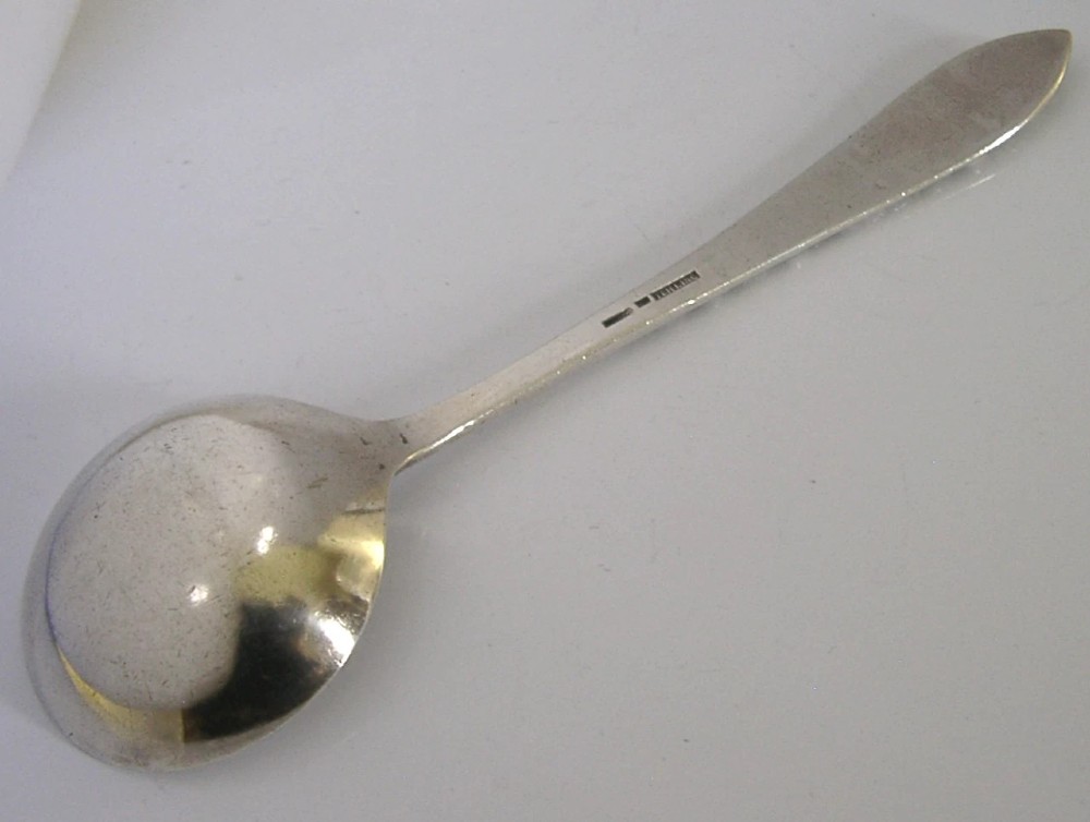 An antique silver serving ladle featuring a rounded circular bowl and a detailed dragon relief chased along the handle. View IV