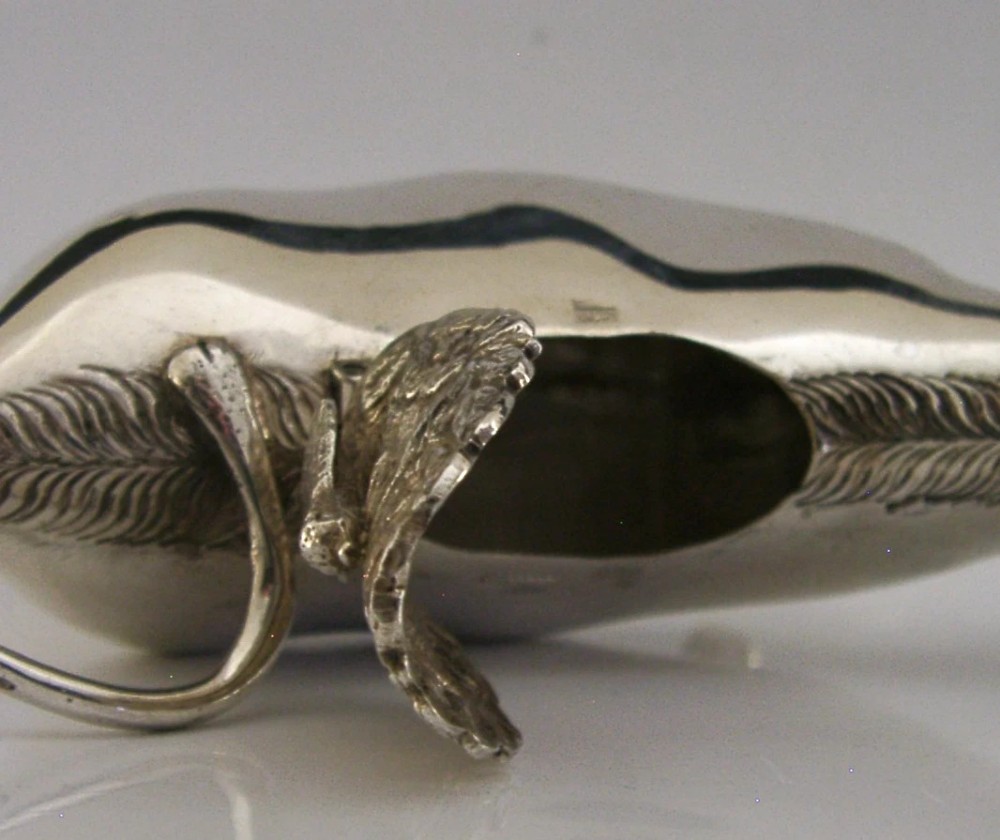 A sterling silver novelty cow creamer featuring a hollow cast body, a hinged lid decorated with floral motifs on the back, and a looped tail handle. View VIII