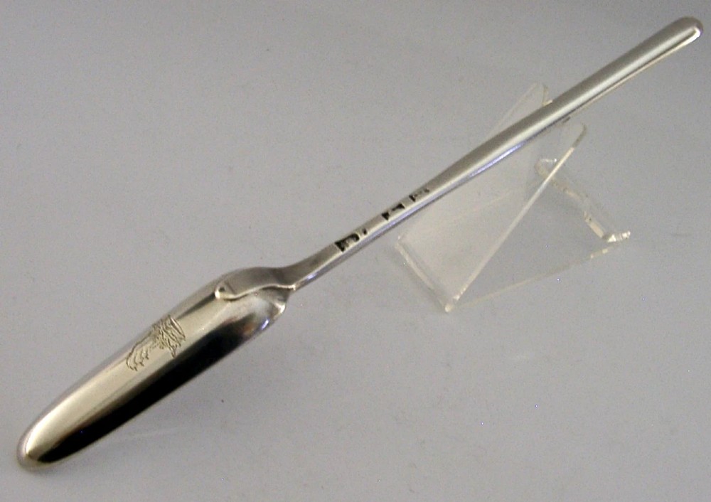 A Georgian sterling silver marrow scoop featuring an engraved family crest on the elongated scoop and stamped hallmarks along the narrow handle. View III