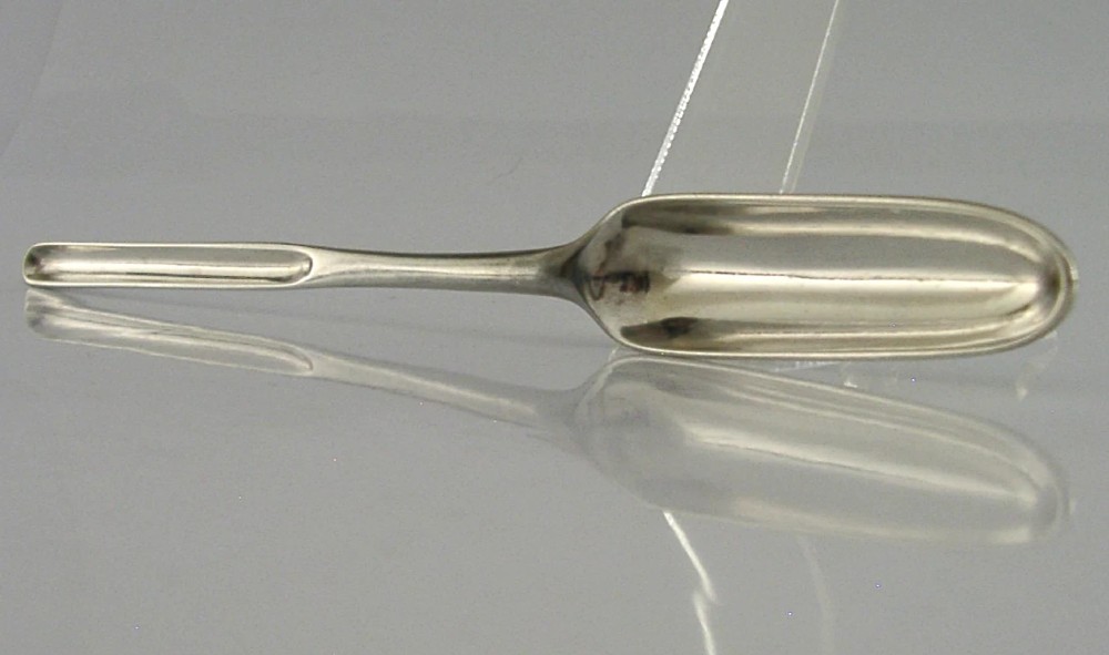 A Georgian sterling silver marrow scoop featuring an engraved family crest on the elongated scoop and stamped hallmarks along the narrow handle. View IV