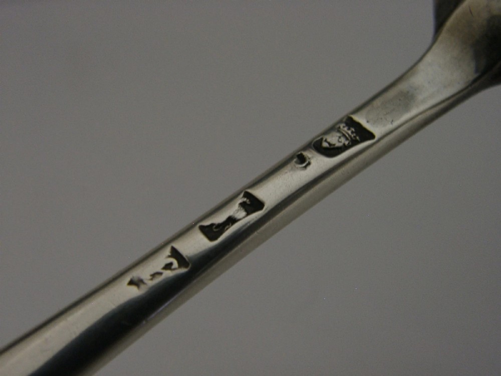 A Georgian sterling silver marrow scoop featuring an engraved family crest on the elongated scoop and stamped hallmarks along the narrow handle. View VII