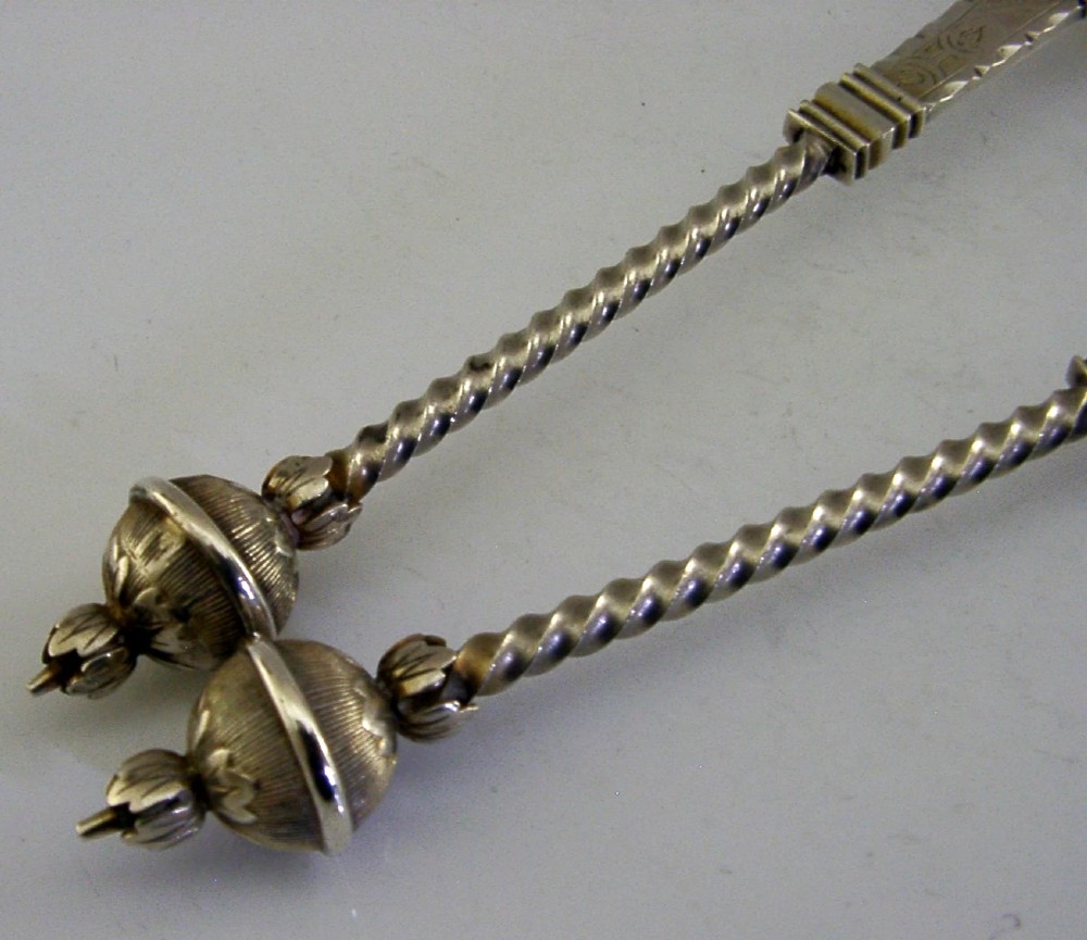 A pair of antique Norwegian silver serving spoons featuring round engraved bowls, twisted wire stems, and decorative knop finials. View IV