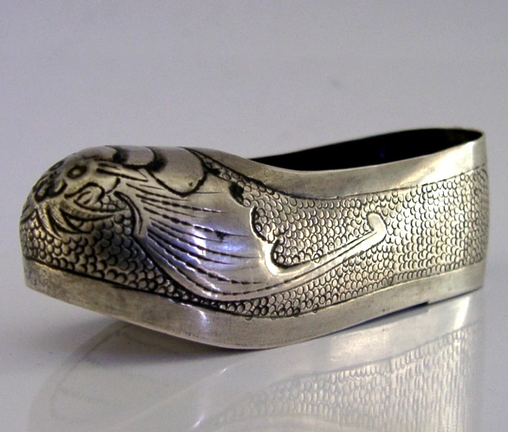 An antique Chinese export silver novelty pin cushion formed in the shape of a traditional slipper, featuring chased bat motifs and textured surface decoration. View IV