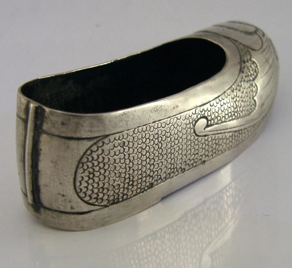 An antique Chinese export silver novelty pin cushion formed in the shape of a traditional slipper, featuring chased bat motifs and textured surface decoration. View VI