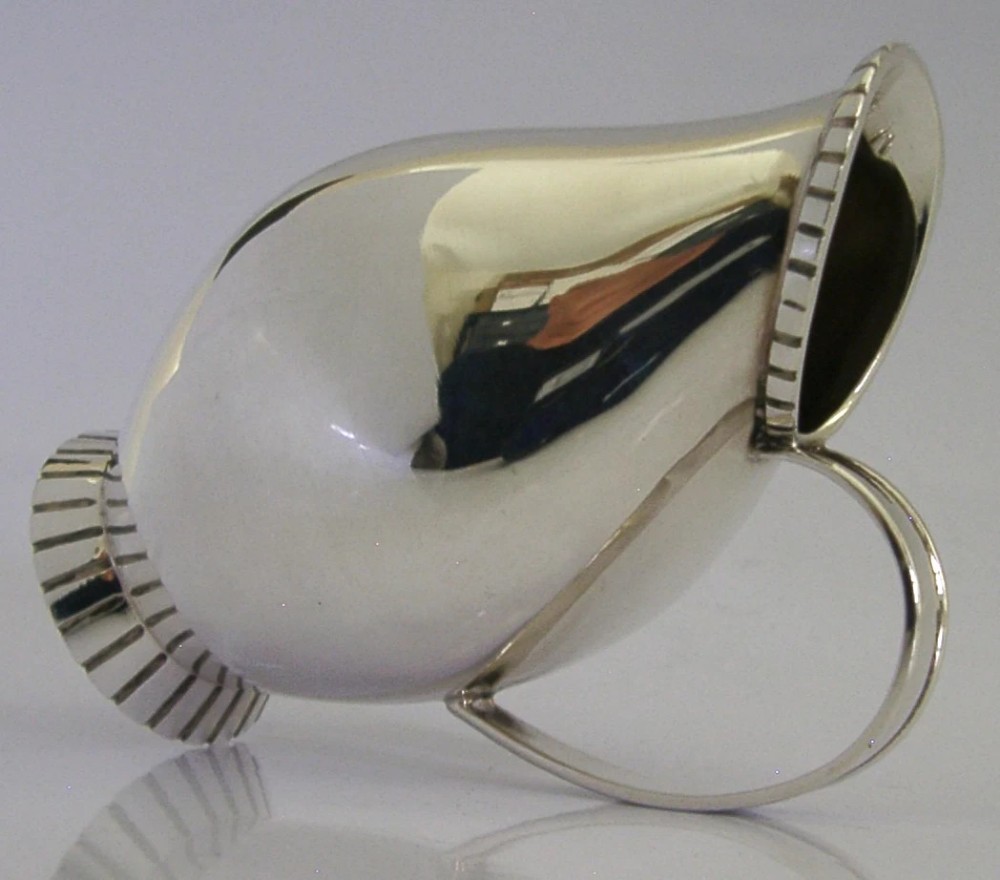 A pear-shaped mid-century sterling silver cream jug featuring a fluted rim, a matching fluted foot ring, and a single loop handle. View III
