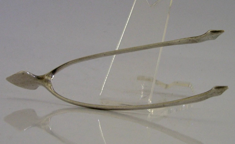 A pair of solid sterling silver sugar tongs shaped like a bird wishbone with visible British hallmarks on the upper bridge. View V