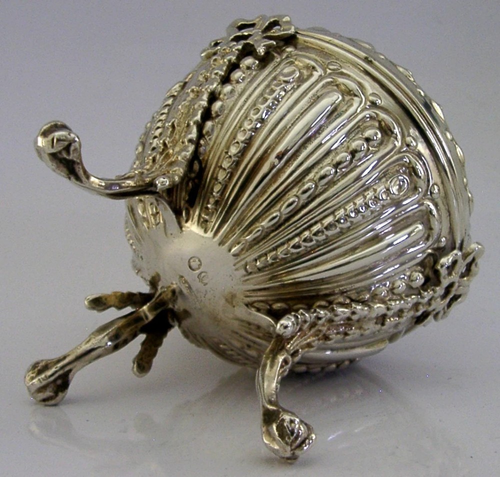 A Victorian sterling silver string box featuring detailed repousse fluting, a domed lid, and three ornate scrolled feet. View V