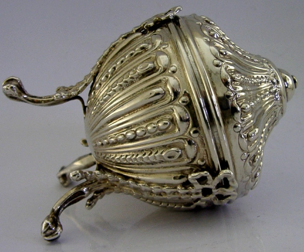 A Victorian sterling silver string box featuring detailed repousse fluting, a domed lid, and three ornate scrolled feet. View VI