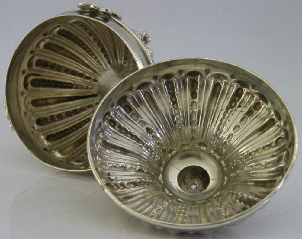 A Victorian sterling silver string box featuring detailed repousse fluting, a domed lid, and three ornate scrolled feet. View VII