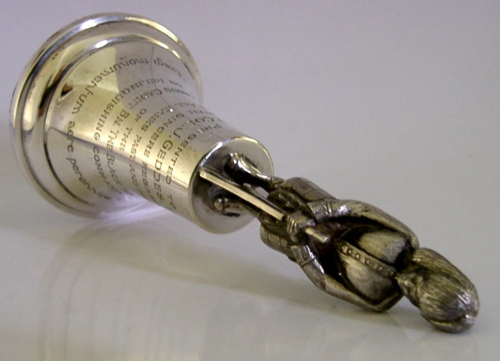 A polished sterling silver table bell topped with a sculpted Black Watch soldier figurine and featuring engraved regimental lettering on the bell body. View VII