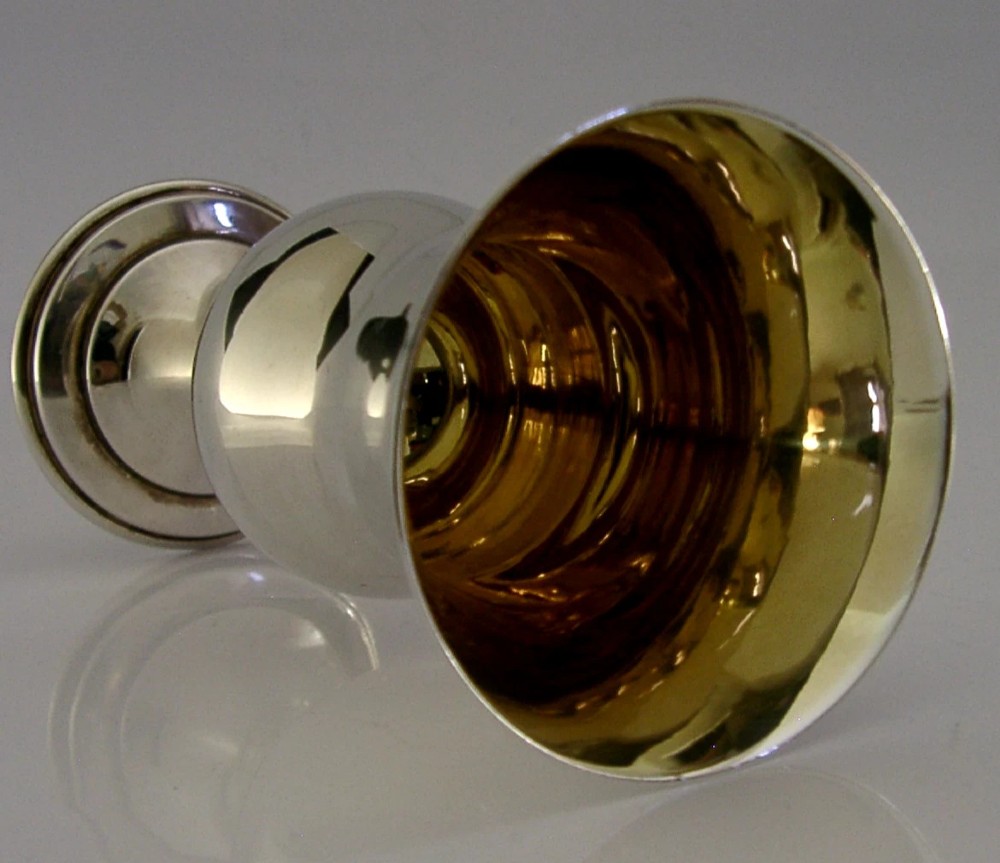 A polished mid-century sterling silver wine goblet featuring a flared rim, gilt interior wash, visible hallmarks, and a circular stepped base. View VII