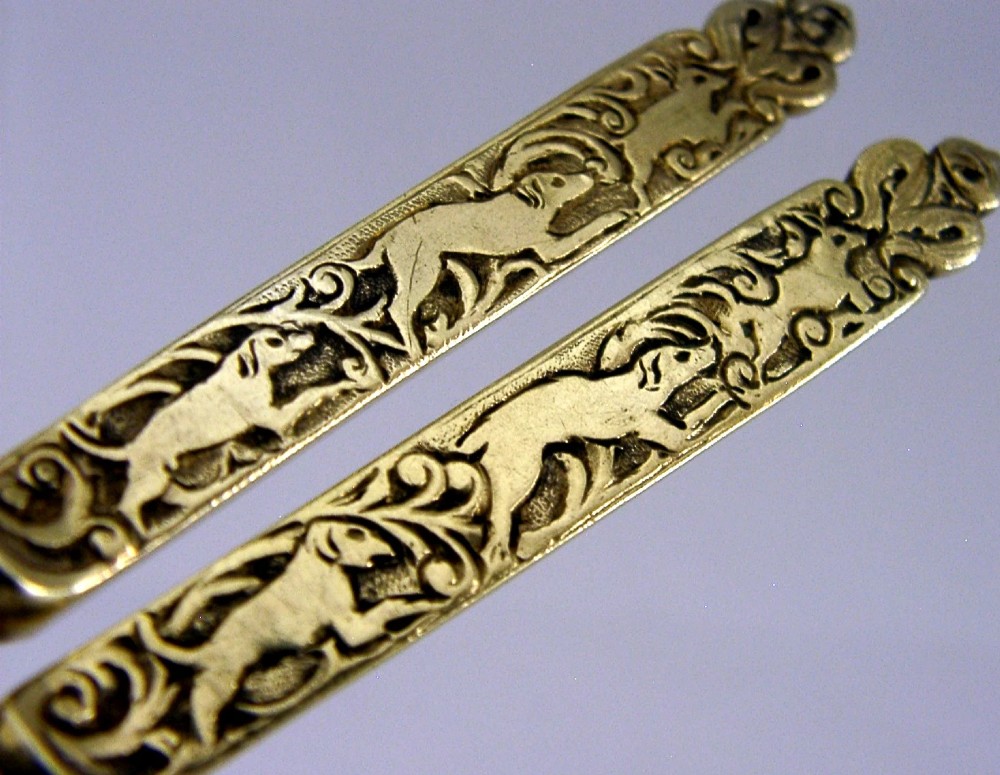 A pair of Victorian sterling silver gilt serving spoons featuring oval bowls and detailed cast handles with grotesque mask and scroll motifs. View IV