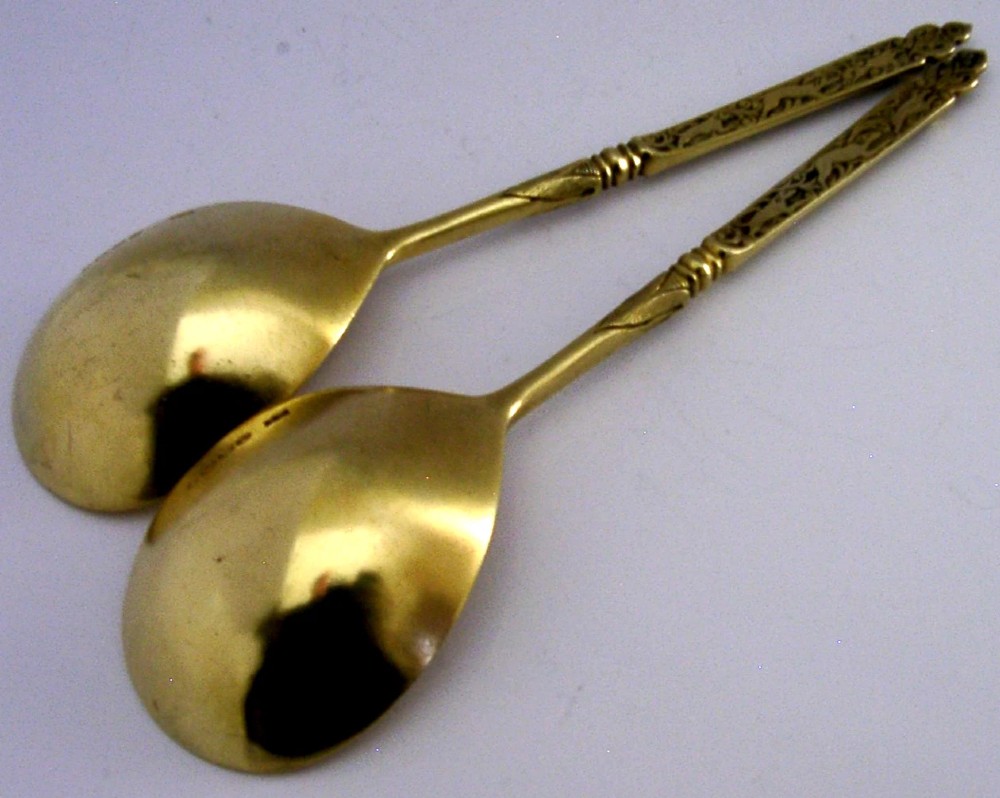 A pair of Victorian sterling silver gilt serving spoons featuring oval bowls and detailed cast handles with grotesque mask and scroll motifs. View VIII