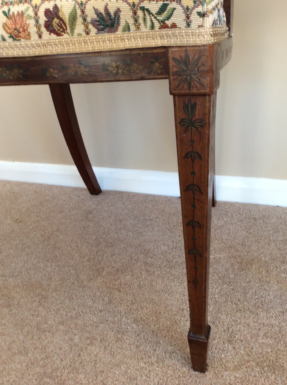 A Georgian open elbow chair with dark wood frame featuring hand-painted floral and musical motifs, an X-shaped back splat with central roundel, and a floral patterned upholstered seat. View IV
