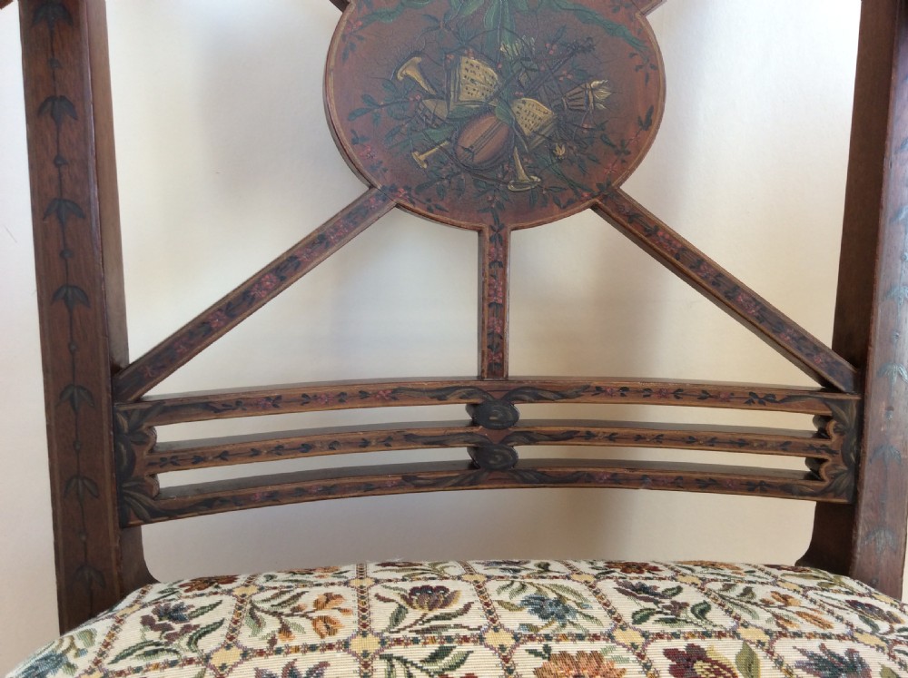 A Georgian open elbow chair with dark wood frame featuring hand-painted floral and musical motifs, an X-shaped back splat with central roundel, and a floral patterned upholstered seat. View VI
