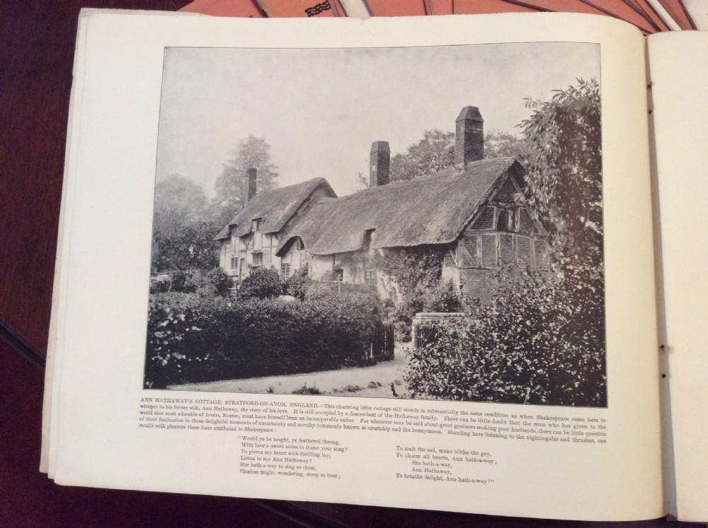 A fan-shaped arrangement of sixteen dusty pink late Victorian softcover portfolios with a main title cover reading Portfolio of Photographs by John L Stoddard. View II