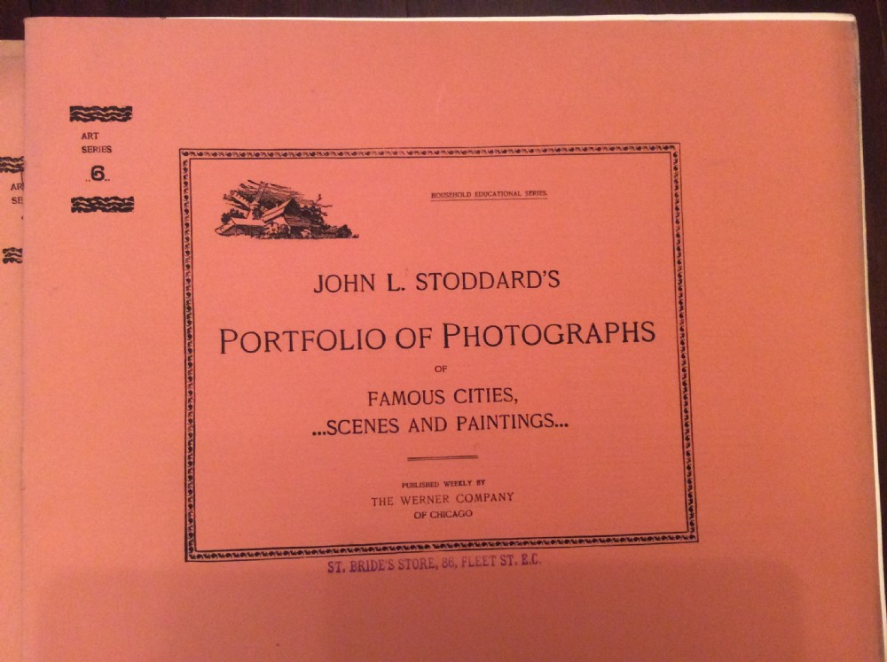 A fan-shaped arrangement of sixteen dusty pink late Victorian softcover portfolios with a main title cover reading Portfolio of Photographs by John L Stoddard. View XII