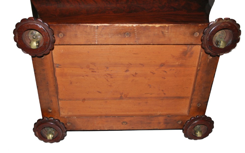 A George IV mahogany sarcophagus-form cellarette with a stepped hinged lid, keyhole escutcheon, and carved lobed feet. View II