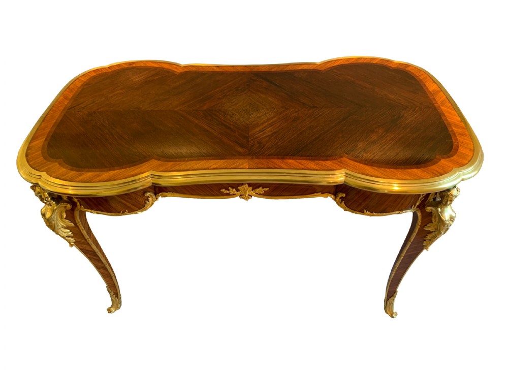 A serpentine kingwood and rosewood centre table featuring cabriole legs with decorative ormolu female bust mounts and gilt sabots. View II