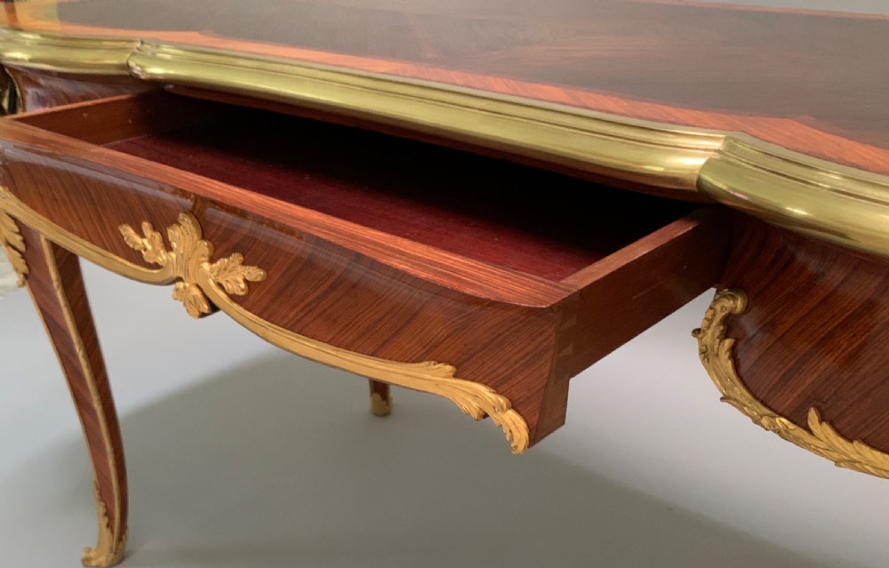 A serpentine kingwood and rosewood centre table featuring cabriole legs with decorative ormolu female bust mounts and gilt sabots. View V
