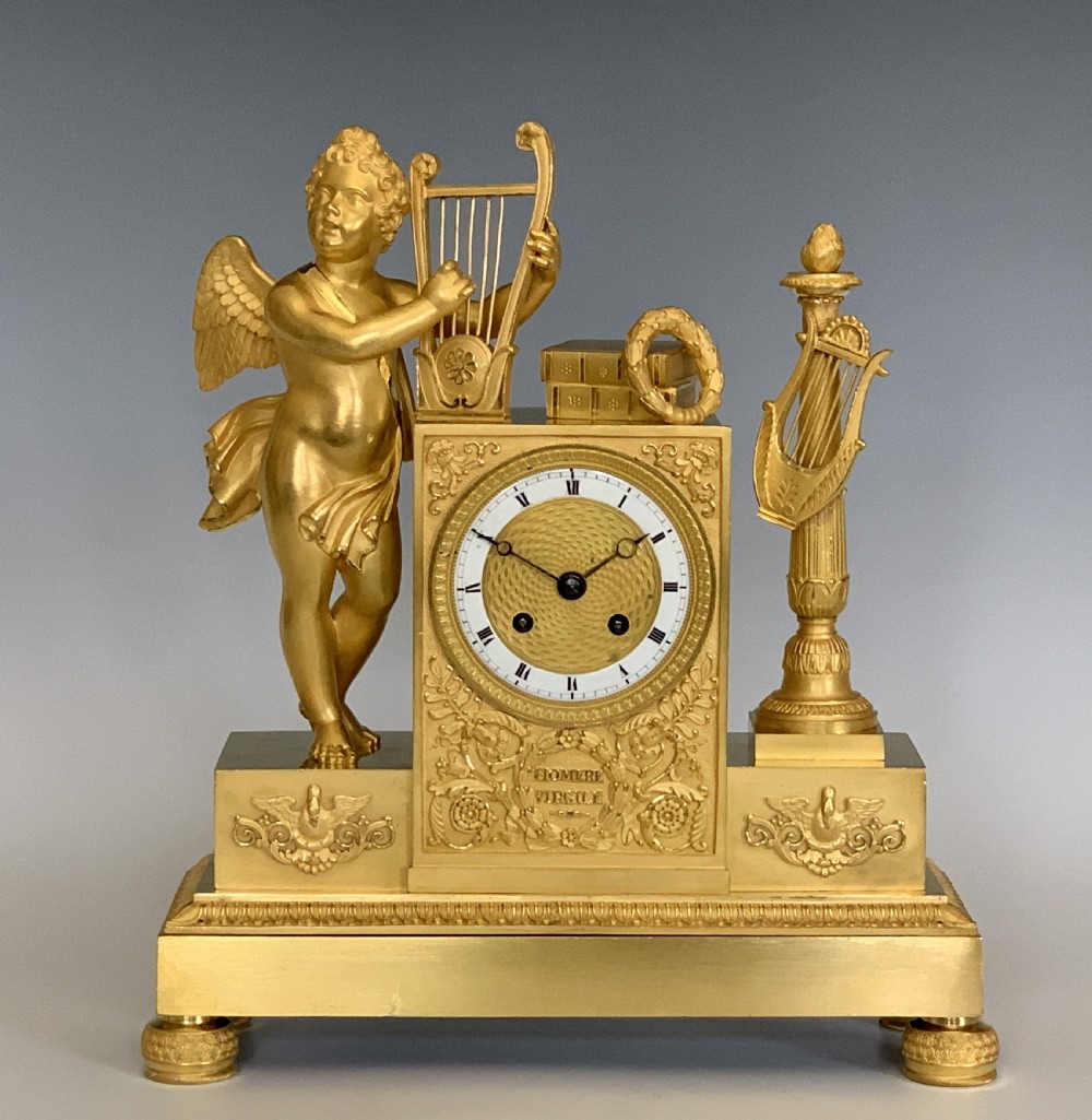 A 19th-century French Empire gilt bronze mantel clock featuring a cherub figure holding a lyre alongside classical decorative elements. View II