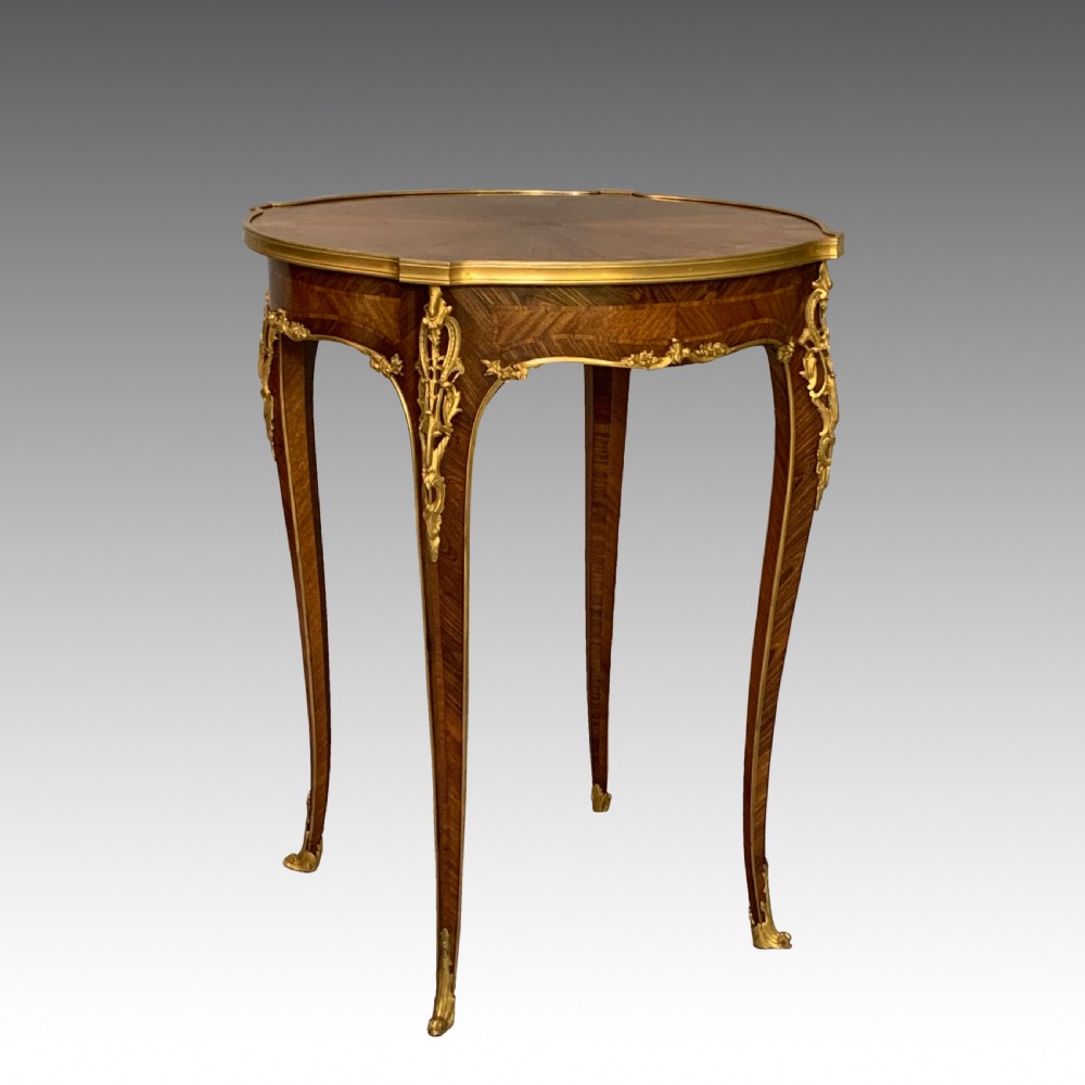 A French Louis XV style kingwood occasional table featuring geometric parquetry, curved cabriole legs, and ornate gilt-bronze mounts.