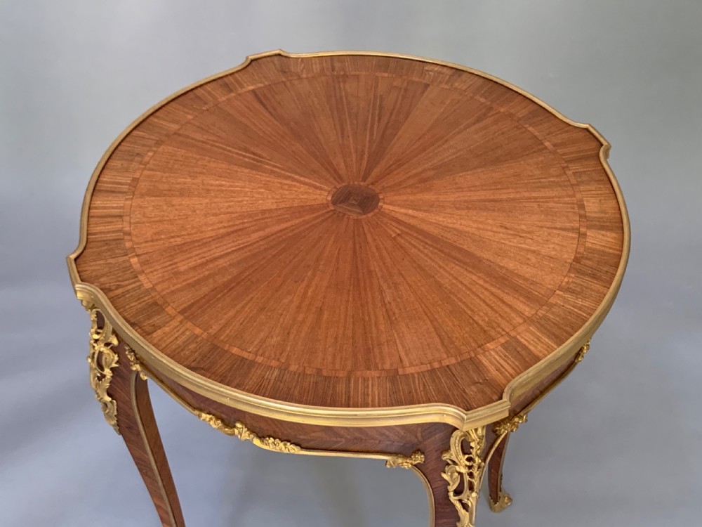 A French Louis XV style kingwood occasional table featuring geometric parquetry, curved cabriole legs, and ornate gilt-bronze mounts. View VI