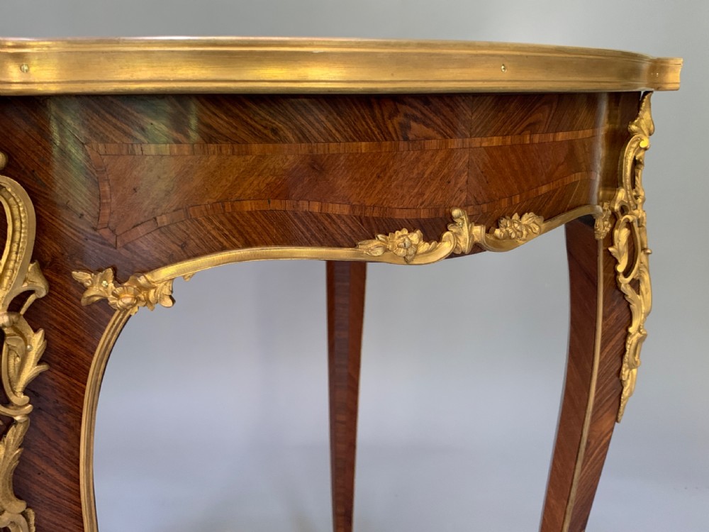 A French Louis XV style kingwood occasional table featuring geometric parquetry, curved cabriole legs, and ornate gilt-bronze mounts. View VII