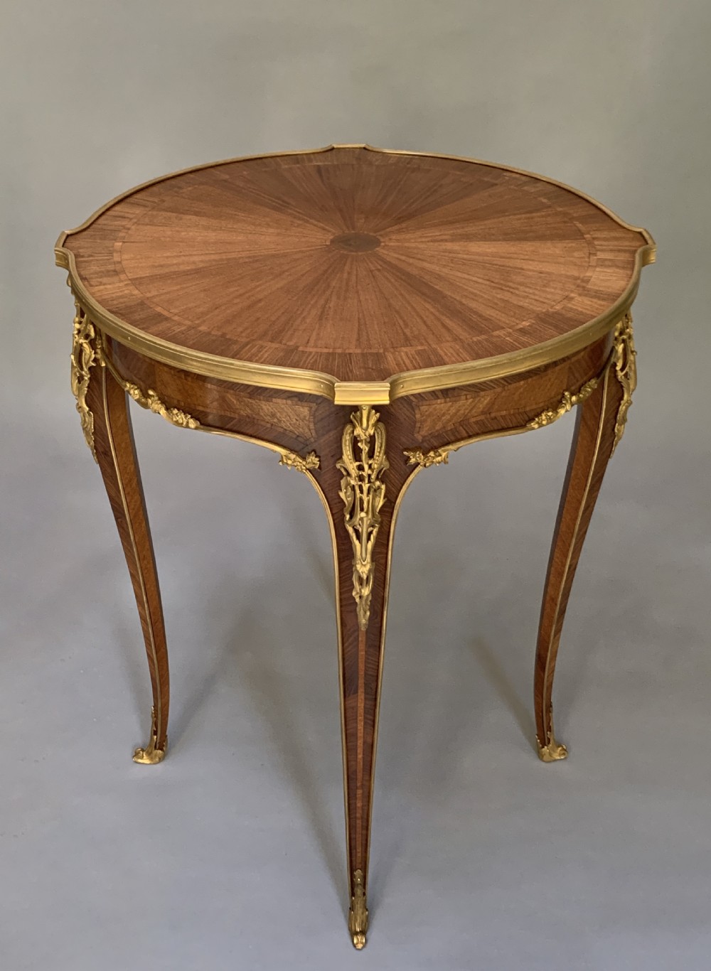 A French Louis XV style kingwood occasional table featuring geometric parquetry, curved cabriole legs, and ornate gilt-bronze mounts. View X