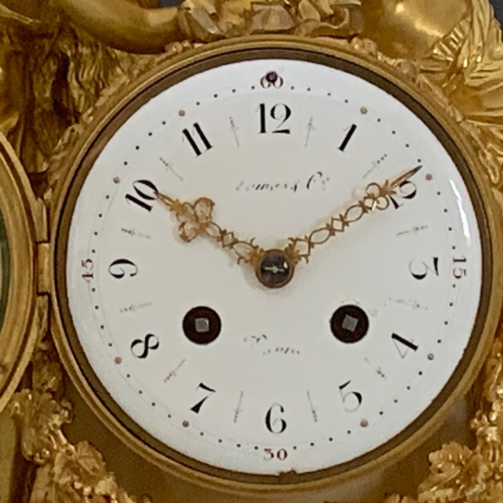 A Louis XVI style French ormolu and white marble mantel clock depicting two sculptural classical female figures flanking a circular white enamel dial. View VI