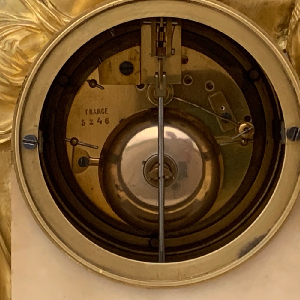 A Louis XVI style French ormolu and white marble mantel clock depicting two sculptural classical female figures flanking a circular white enamel dial. View IX