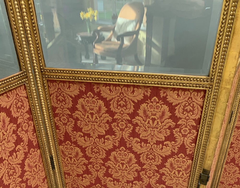 A Victorian four-panel folding screen with gilded wood frames, arched tops, upper mirrored glass inserts, and lower red damask fabric panels. View V
